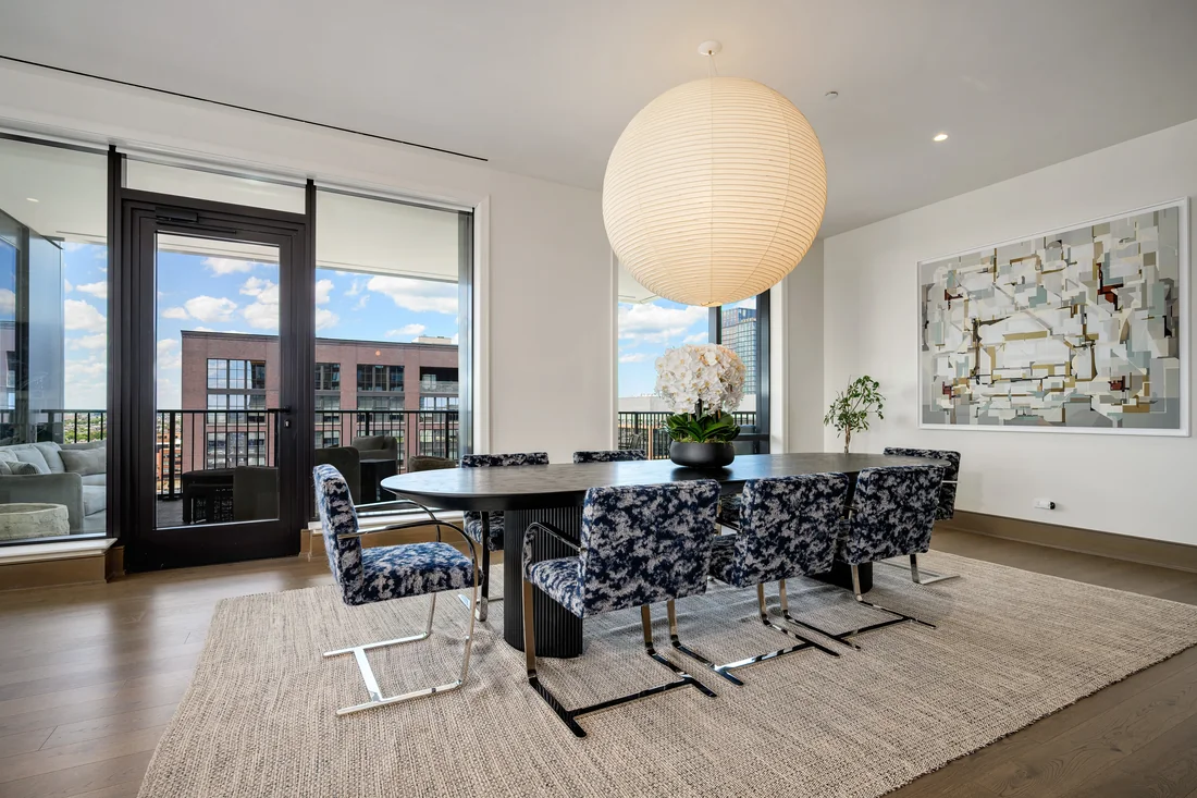 City dining room with a sculptural paper pendant and patterned chairs