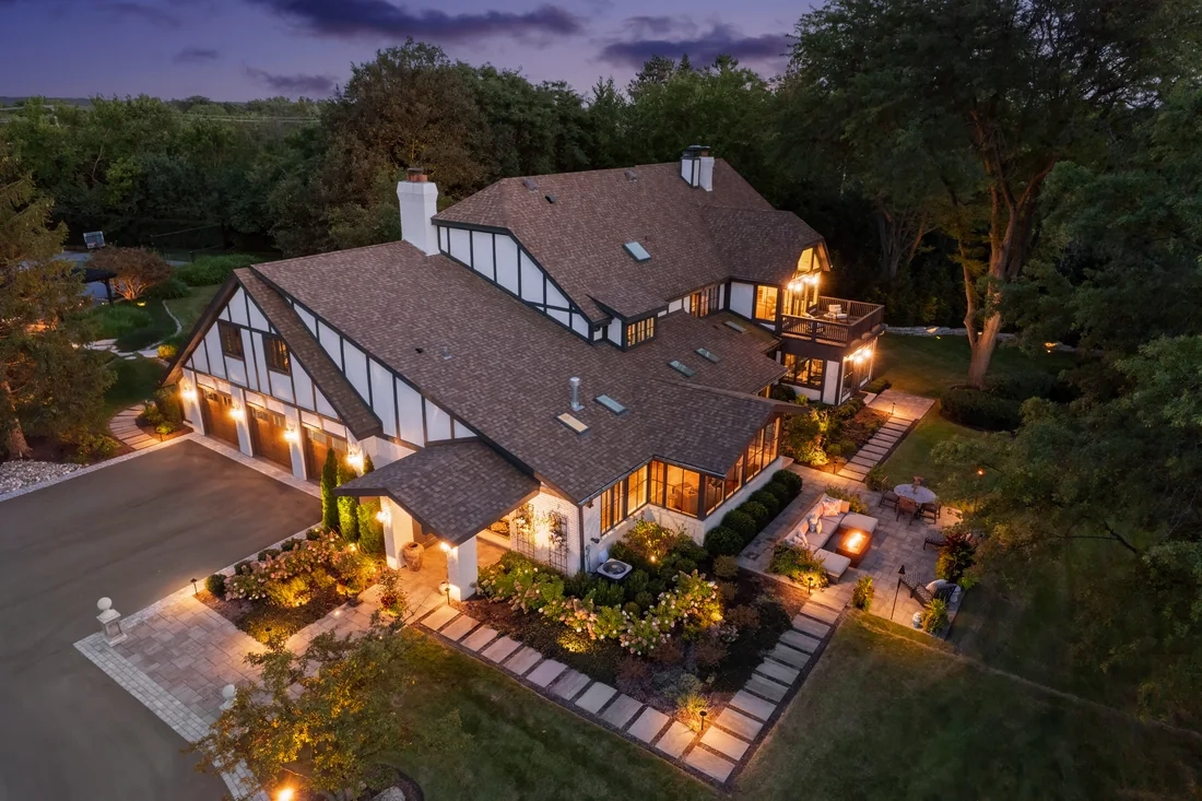 Elevated evening view of a home and its illuminated landscaped grounds