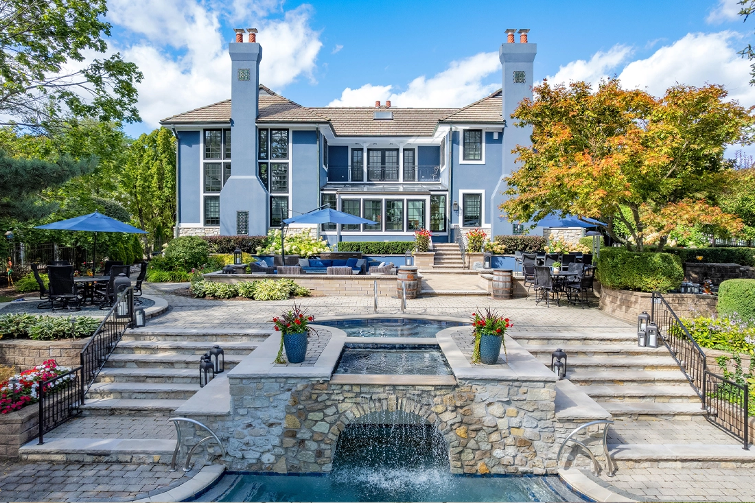 Stone courtyard with an outdoor fireplace and white dining furniture