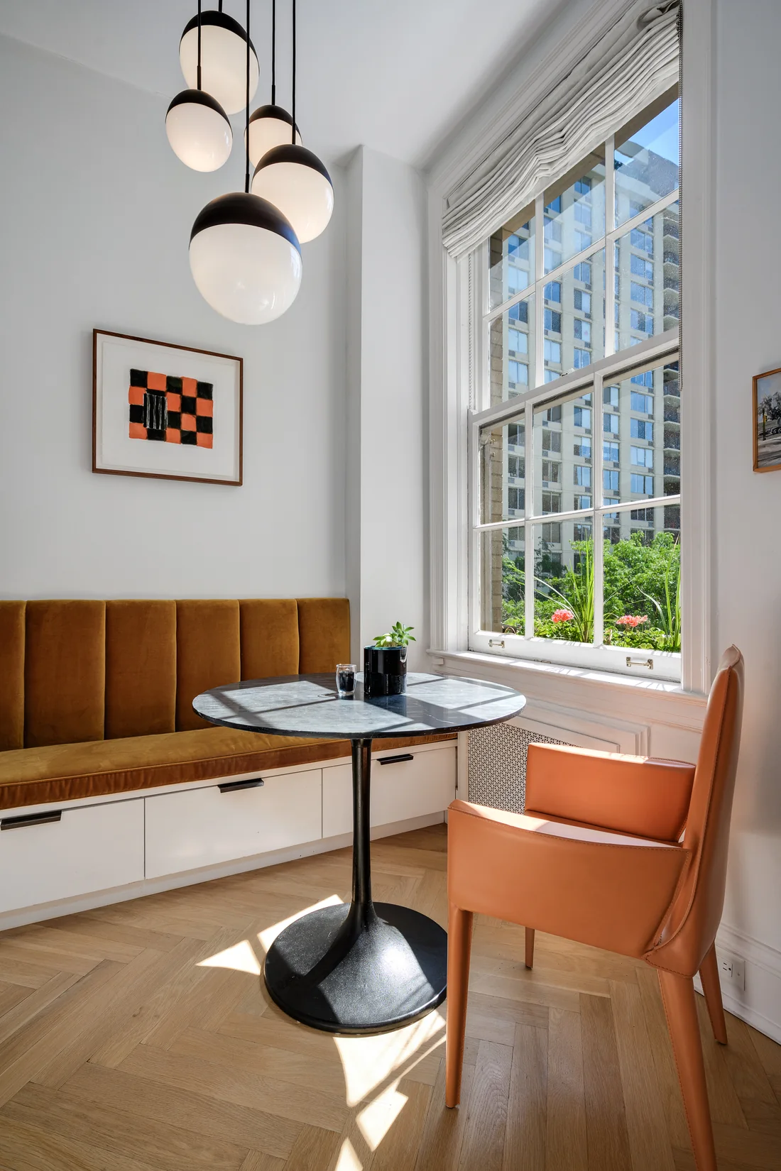 Breakfast nook with warm leather seating, globe pendants and a tall window