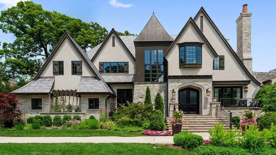 Stone and stucco residence with steep gables and mature landscaping