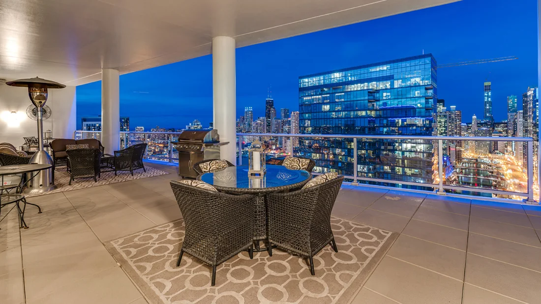 Evening dining room with panoramic windows framing the blue Chicago skyline