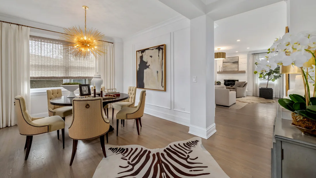 Elegant dining room opening into a white kitchen