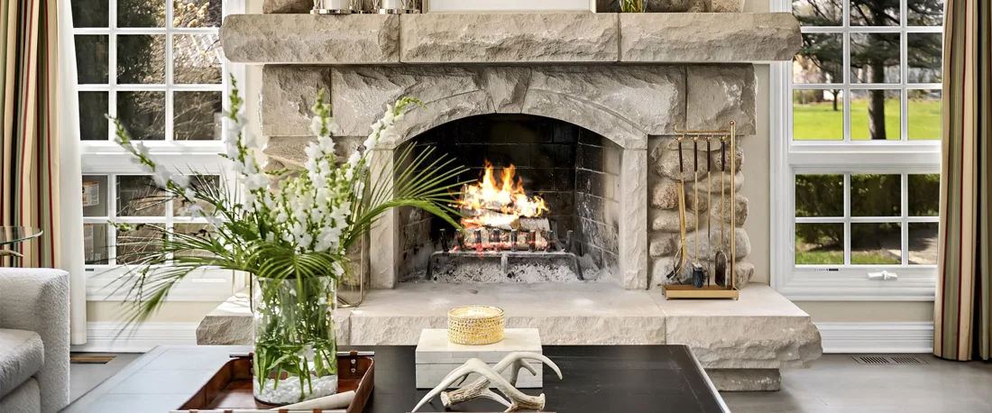 Stone fireplace and comfortable seating in a sunlit garden room